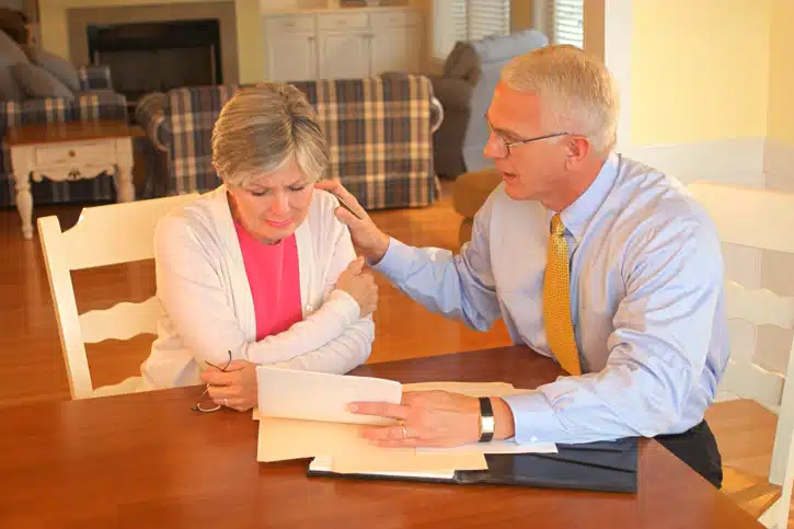 a man consoling a woman as they read a letter