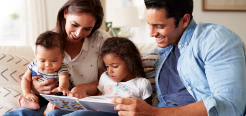 a mother and father reading to the kids