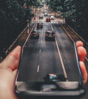 a person holding a phone with a road graphic