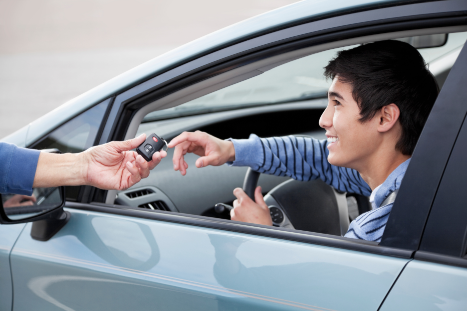 a person handing a teen driver car keys