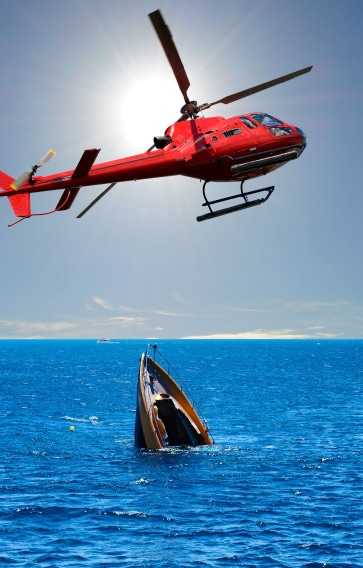 a helicopter flying over a sinking boat
