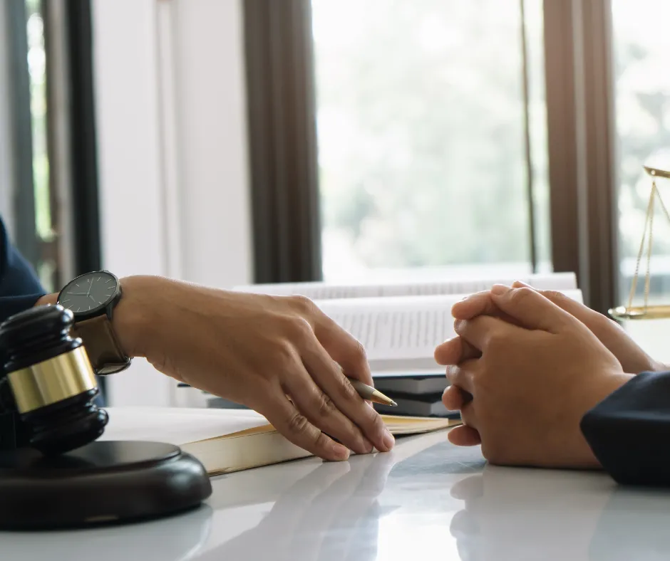 A person speaking with a lawyer in a consultation setting.
