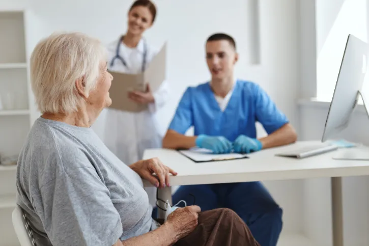 A woman having a conversation with doctors in a medical setting.