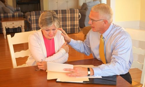 a man consoling a woman as they read a letter