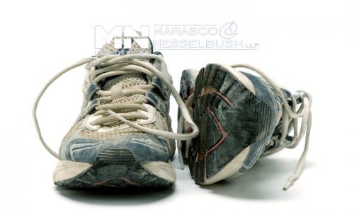 Pair of old used running shoes isolated on white background