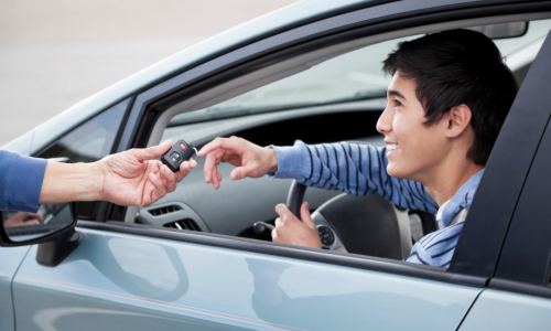 a person handing a teen driver car keys